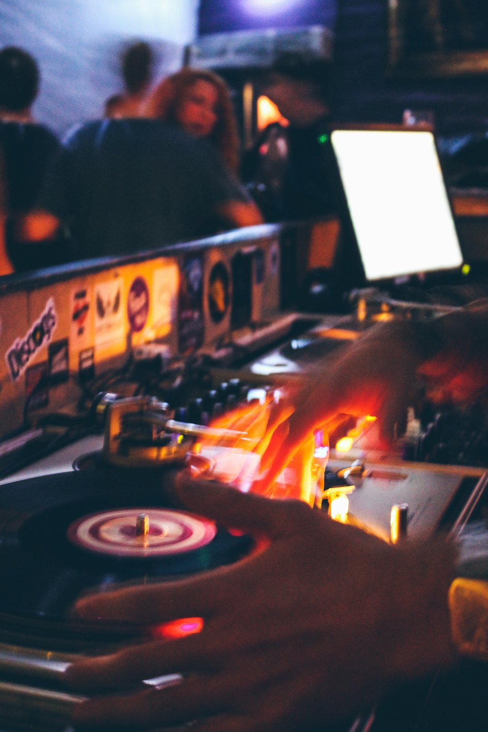 DJ's handen die muziek mixen op draaitafels in een club.