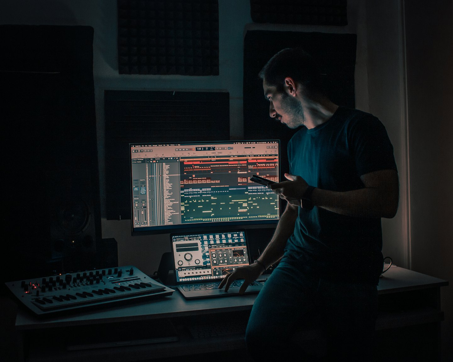 Man werkt aan muziekproductiesoftware in een studio.