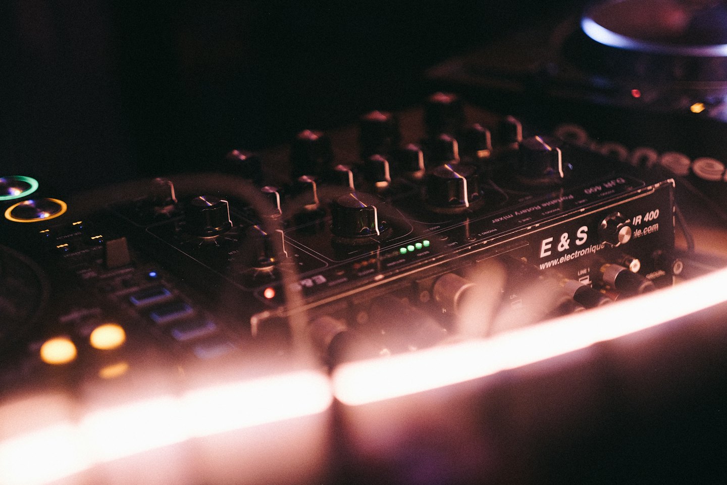 DJ-mixer en draaitafelapparatuur met veel knoppen en bedieningselementen.